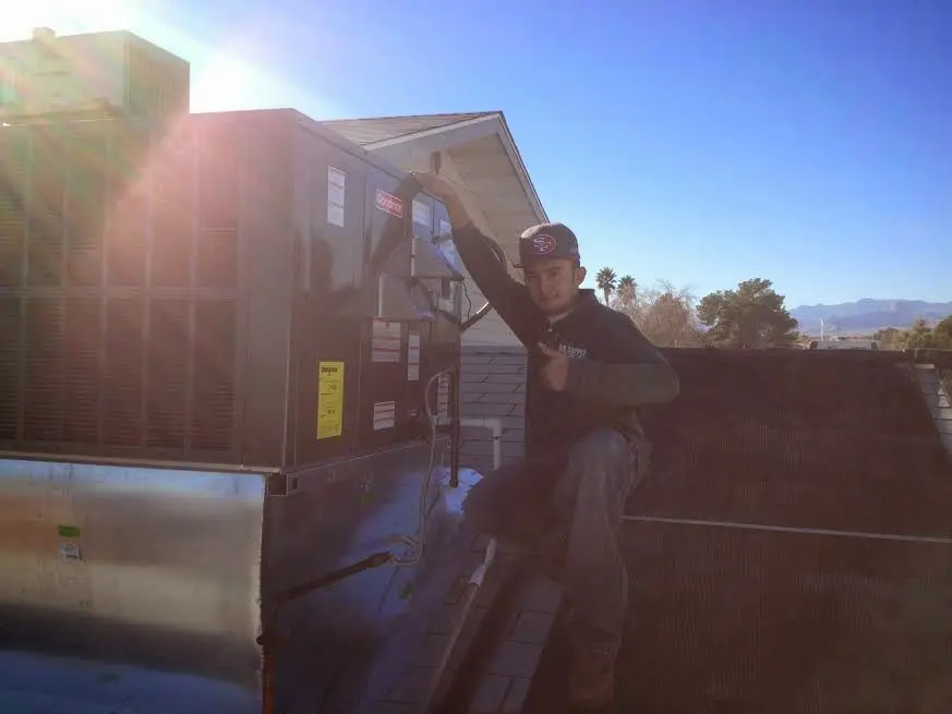 HVAC technician performing AC Tune-Up on a rooftop unit in Fishersville